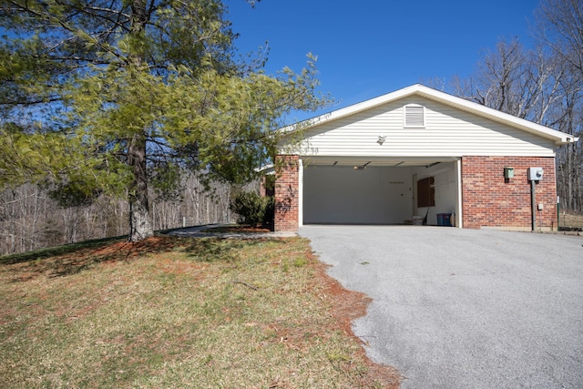 view of property exterior with a garage, driveway, and brick siding