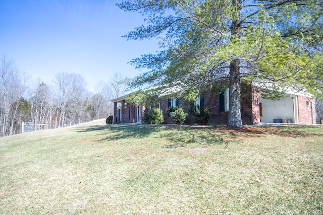 view of front of property with an attached garage, brick siding, and a front yard