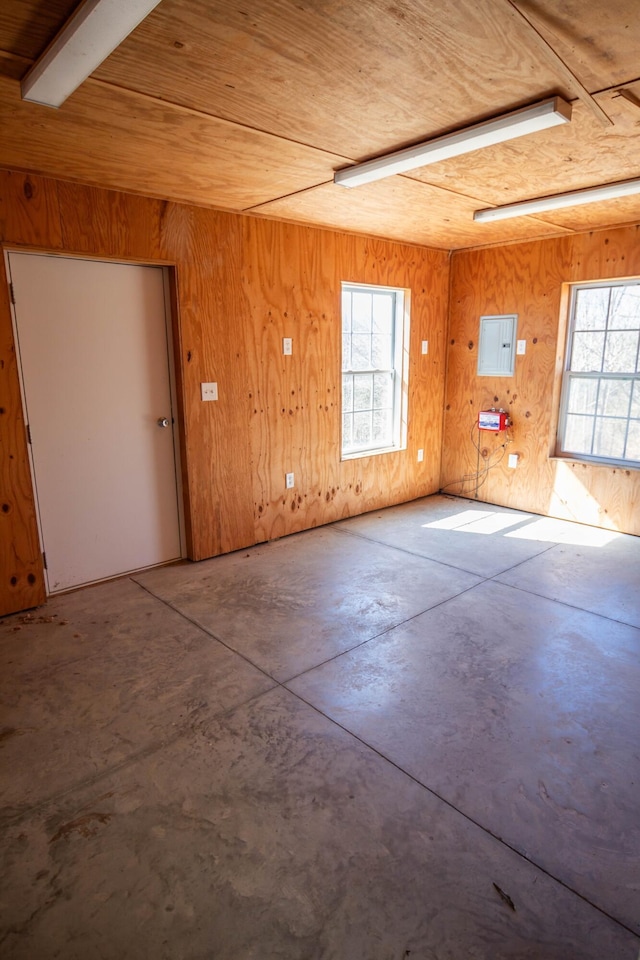 spare room featuring wooden ceiling, concrete floors, plenty of natural light, and electric panel