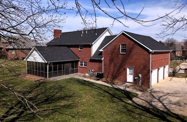 415 David Ln, Winchester, KY 40391 - rear view of property featuring a sunroom, brick siding, a chimney, concrete driveway, and an attached garage