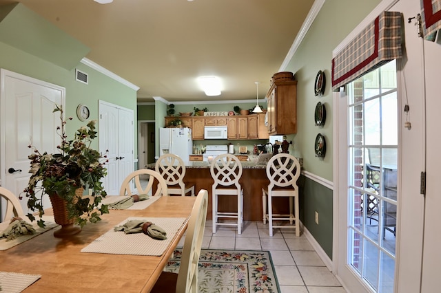 kitchen featuring ornamental molding, a peninsula, white appliances, and light tile patterned floors