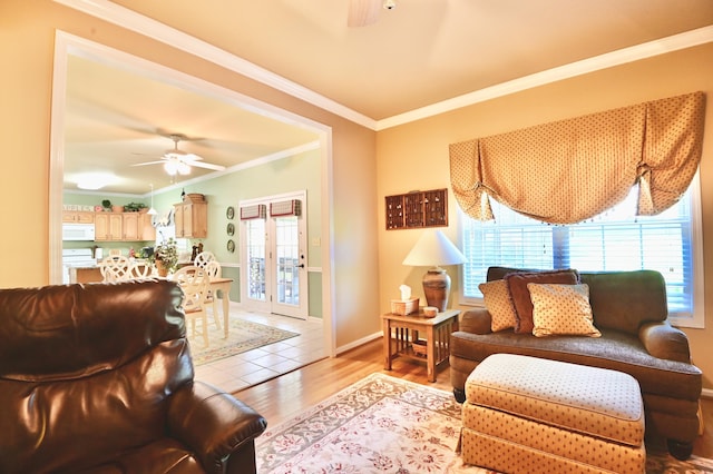 living room with baseboards, light wood finished floors, a ceiling fan, and crown molding