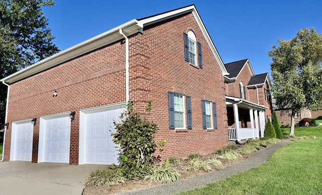 view of home's exterior with driveway, brick siding, and an attached garage