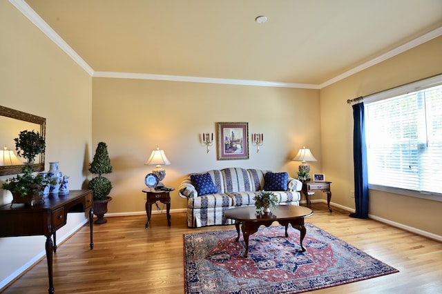 living area with baseboards, ornamental molding, and wood finished floors