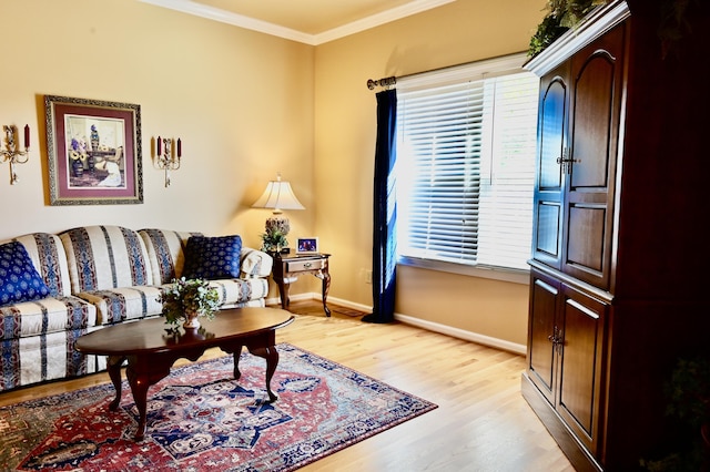 living area featuring ornamental molding, a healthy amount of sunlight, light wood-style floors, and baseboards