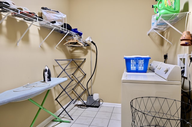 laundry area with laundry area, baseboards, washer and dryer, and tile patterned floors