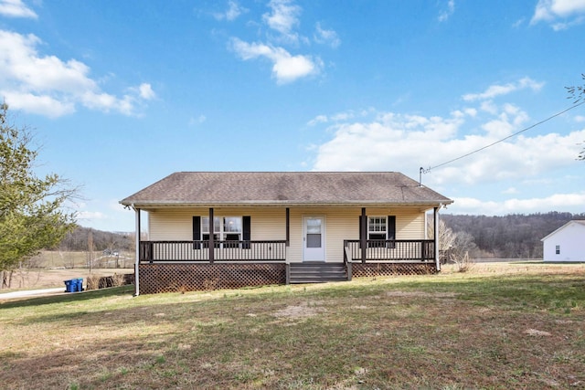 view of front of property featuring roof with shingles, a porch, and a front lawn