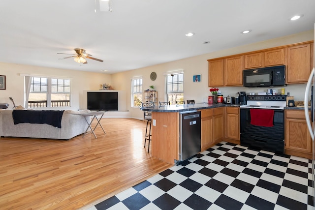 kitchen featuring black microwave, a peninsula, electric stove, stainless steel dishwasher, and light floors