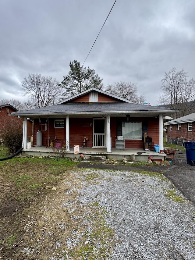 bungalow-style home with a porch and driveway