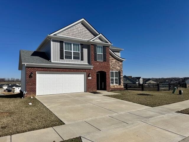 view of front of home featuring concrete driveway, a garage, and fence