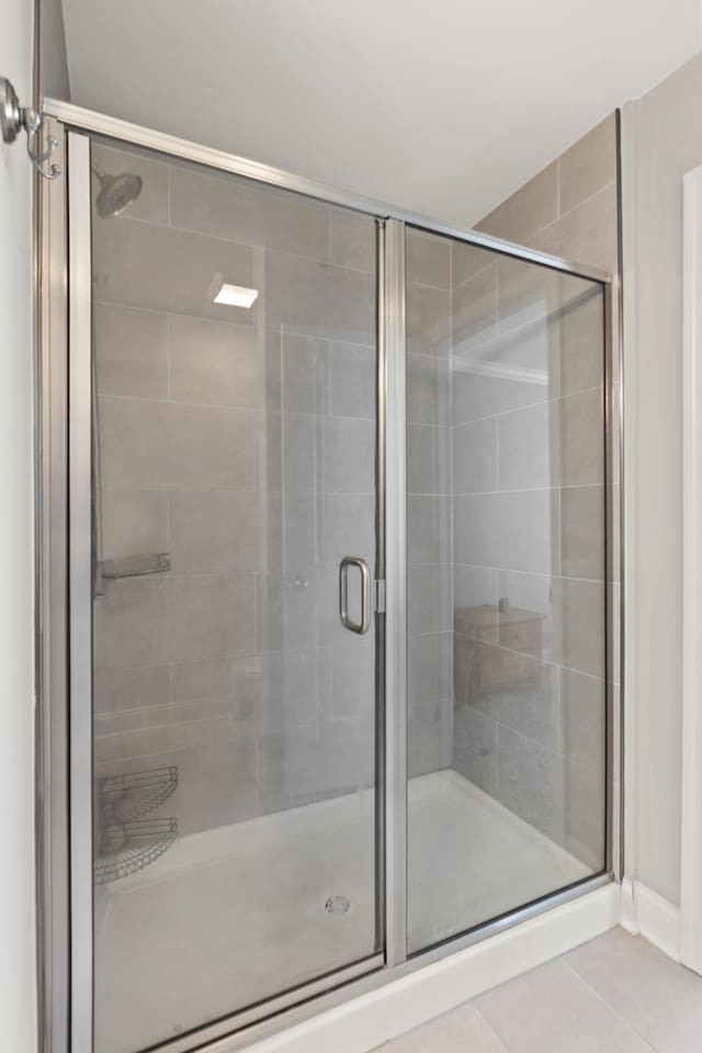 full bathroom featuring a shower stall and tile patterned floors