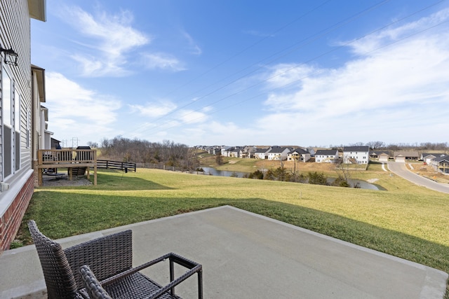 view of patio with a deck with water view and fence