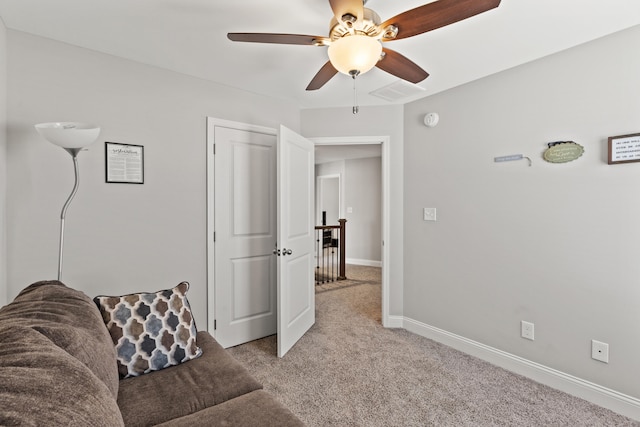 living room with ceiling fan, visible vents, baseboards, and light carpet