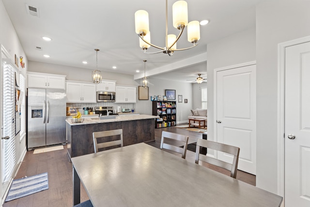 dining room featuring recessed lighting, visible vents, dark wood-style flooring, and ceiling fan with notable chandelier