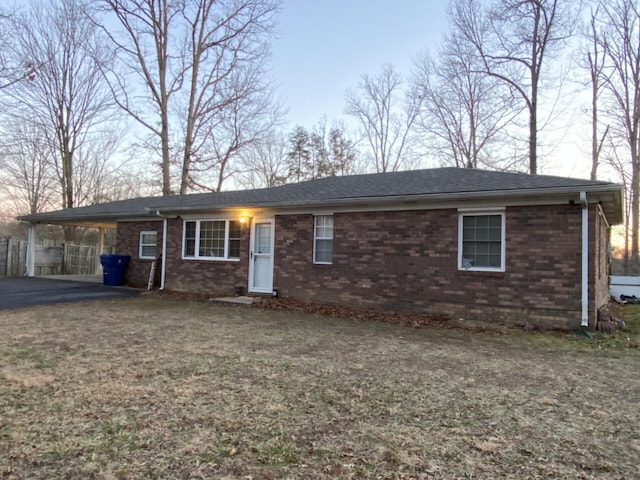 single story home with driveway, an attached carport, and brick siding