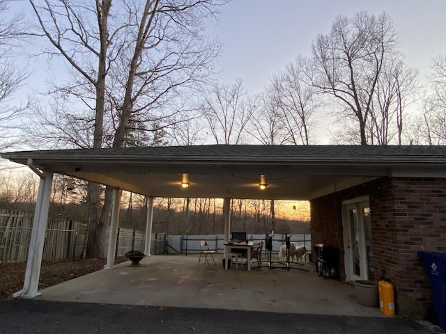 patio terrace at dusk featuring fence