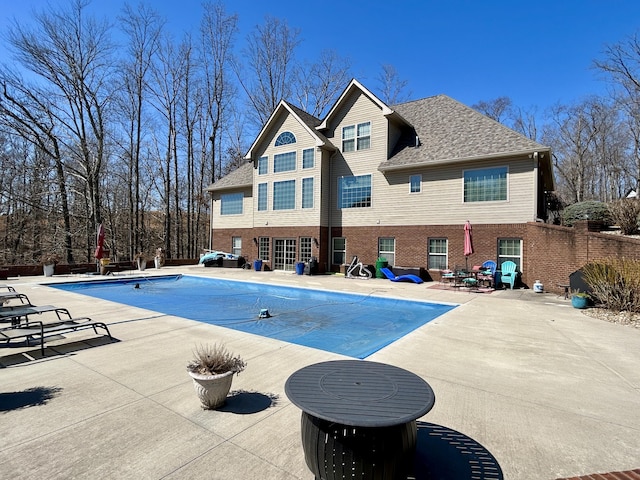 view of swimming pool with a covered pool, fence, and a patio