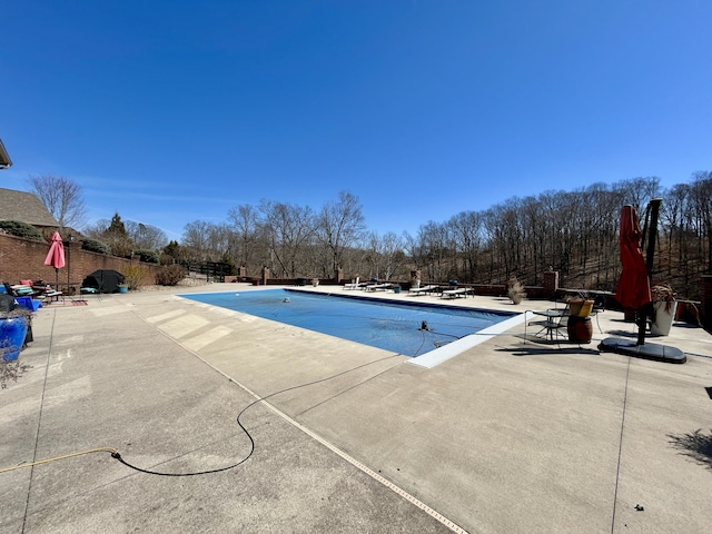 community pool featuring fence and a patio