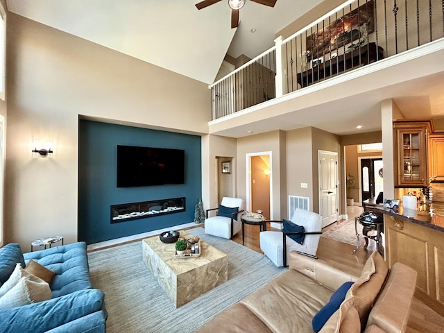 living area with a high ceiling, visible vents, a ceiling fan, and recessed lighting