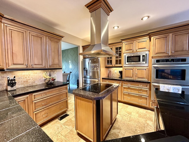 kitchen featuring stainless steel appliances, backsplash, stone tile flooring, and island range hood