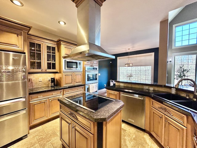 kitchen with appliances with stainless steel finishes, dark countertops, island exhaust hood, and a sink