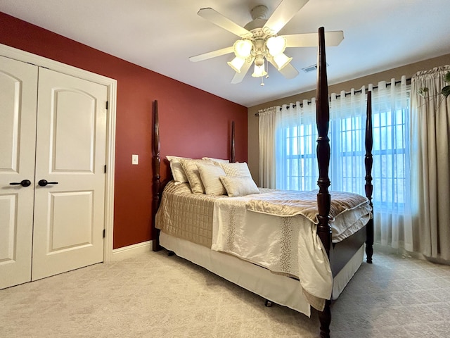 bedroom featuring baseboards, visible vents, a ceiling fan, and light colored carpet