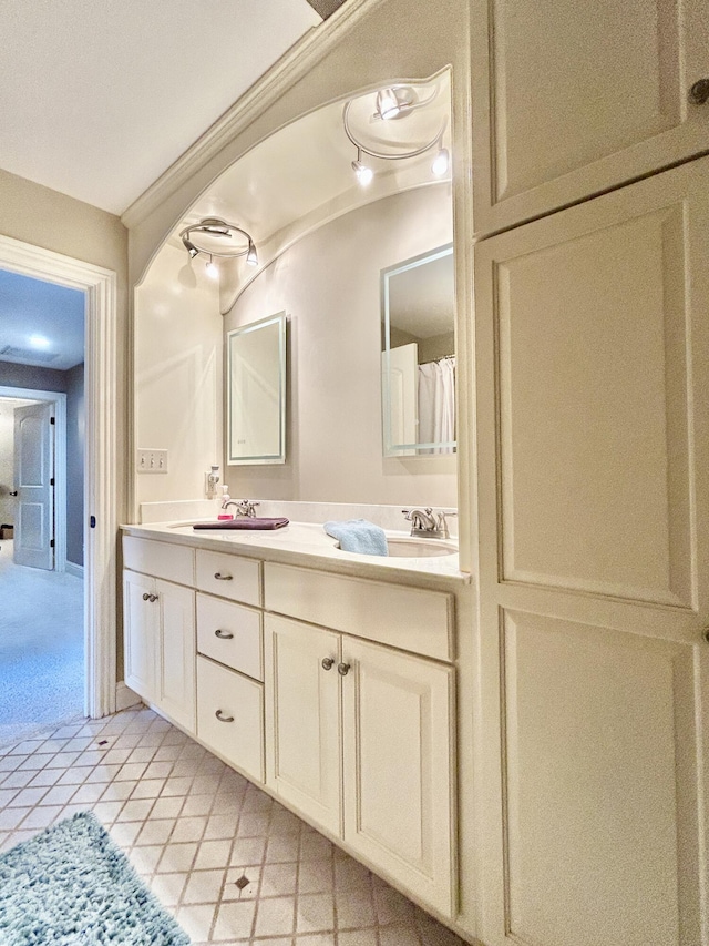 full bathroom with double vanity, a sink, and tile patterned floors