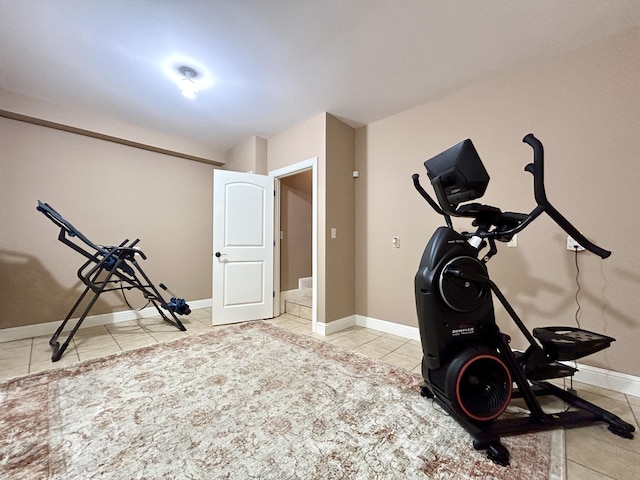 exercise area with baseboards and tile patterned floors