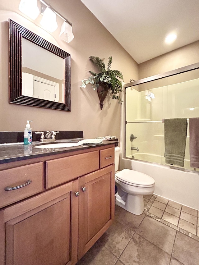 full bath featuring toilet, tile patterned flooring, combined bath / shower with glass door, and vanity