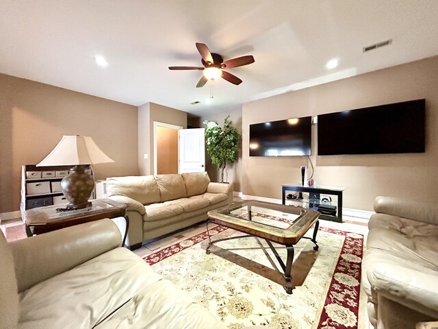 living area featuring baseboards, visible vents, and a ceiling fan