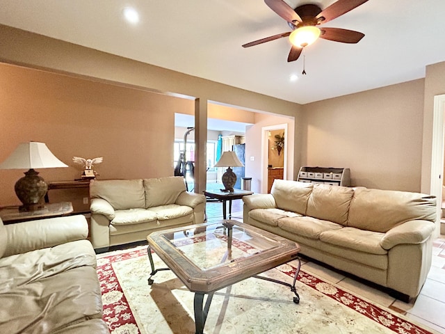 living area with a ceiling fan and light tile patterned floors