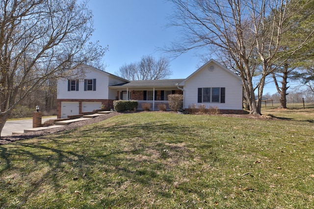 tri-level home with a garage, driveway, a front yard, a porch, and brick siding