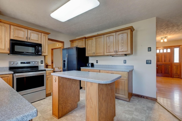 kitchen featuring a center island, light countertops, light brown cabinetry, a textured ceiling, and black appliances