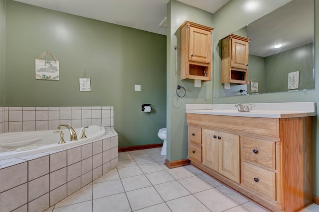 bathroom featuring a garden tub, toilet, vanity, baseboards, and tile patterned floors