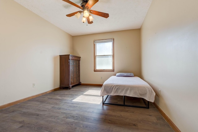 bedroom featuring a textured ceiling, light wood finished floors, a ceiling fan, and baseboards