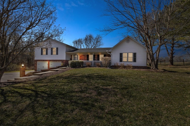 split level home featuring an attached garage, driveway, a front lawn, and brick siding