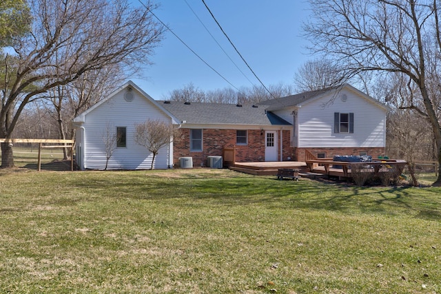 rear view of property with fence, central AC unit, a deck, and a yard