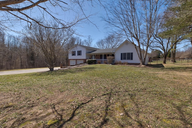 view of front of house with an attached garage, driveway, a front yard, and fence