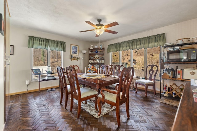 dining area featuring ceiling fan, baseboards, and a textured ceiling