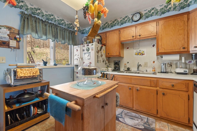 kitchen with white refrigerator with ice dispenser, butcher block counters, backsplash, a sink, and dishwashing machine