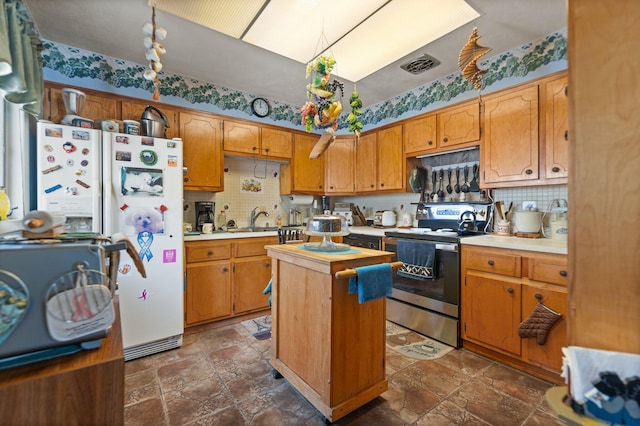 kitchen featuring electric stove, stone finish floor, a center island, light countertops, and a sink