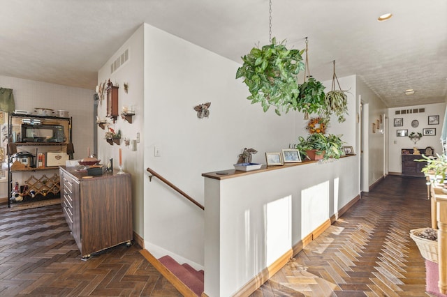 hall featuring recessed lighting, baseboards, visible vents, and an upstairs landing