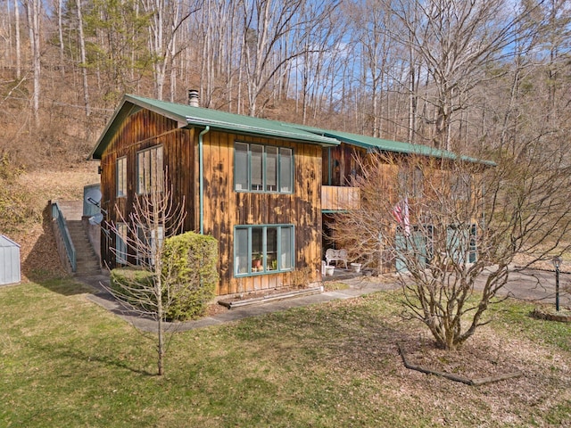 exterior space with metal roof and a front lawn