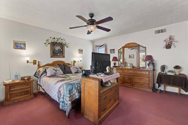 bedroom featuring visible vents, dark carpet, and ceiling fan