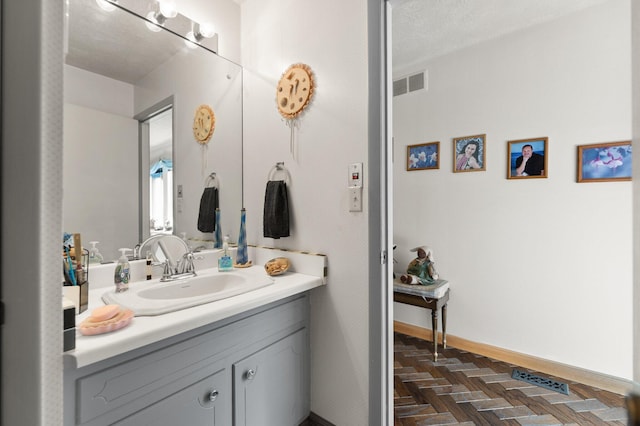 bathroom featuring vanity, visible vents, and baseboards