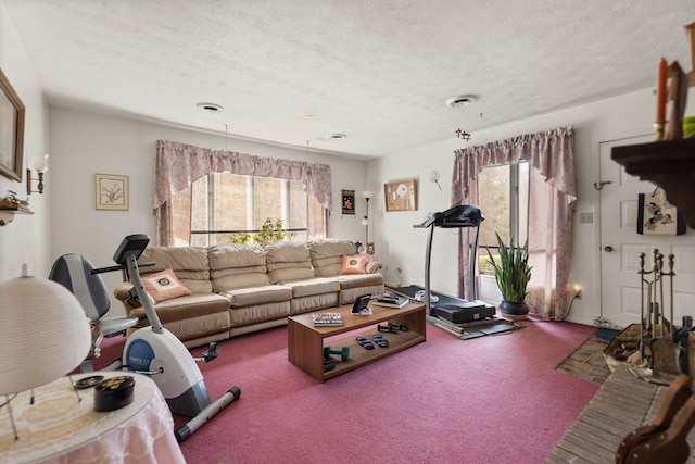 living room featuring carpet, visible vents, and a textured ceiling