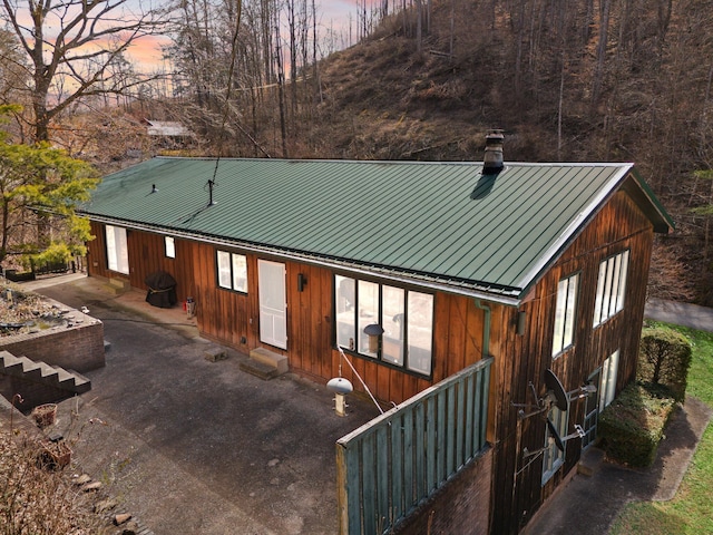 view of front of house featuring a standing seam roof, metal roof, and a chimney