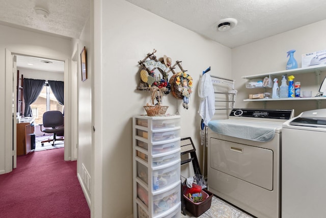 laundry area with a textured ceiling, laundry area, carpet, and washing machine and clothes dryer