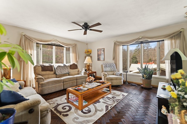 living area with baseboards and a ceiling fan