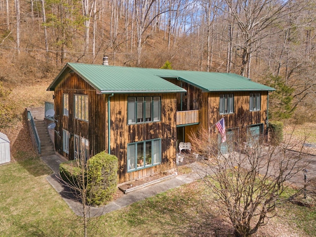 chalet / cabin with metal roof and a front lawn